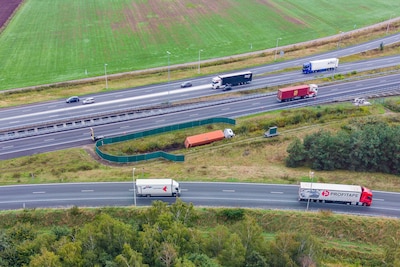 Chauffeur rijdt van snelweg af bij Galder, vrachtwagen zit midden in knooppunt vast in greppel