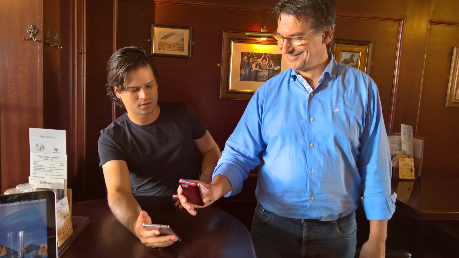 Ondernemer Erwin Heijkamp (rechts) scant de QR-code van ontwikkelaar Kevin van Boeckholtz.