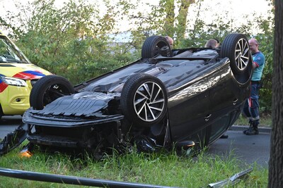 Auto rijdt lantaarnpaal omver en belandt ondersteboven op de weg in Breda
