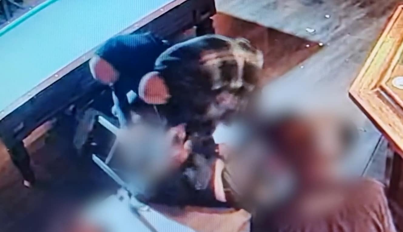 Een videostill van de mishandeling. De twee daders hebben het slachtoffer naar de grond gewerkt.