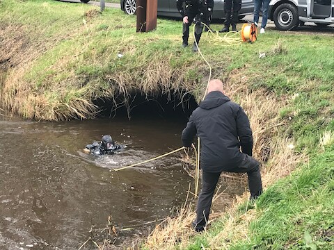 Een duiker van de politie in Steenbergen op zoek naar de kettingzaag waarmee de Belgische loodgieter Johan van der Heyde in stukken is gezaagd.