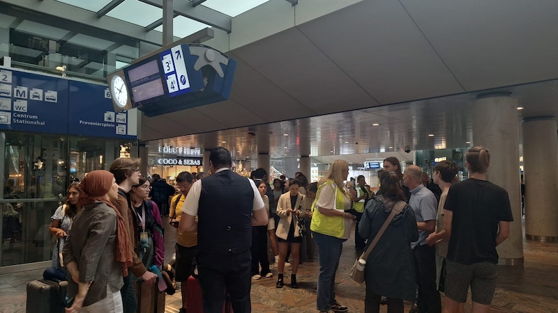 Medewerkers van de NS proberen gestrande reizigers te helpen.