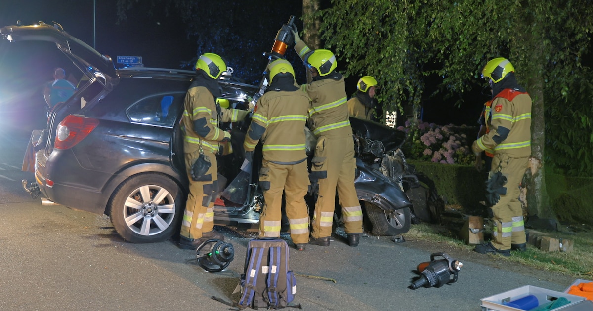Bijrijder vast in auto na botsing tegen boom in Beugen | Foto