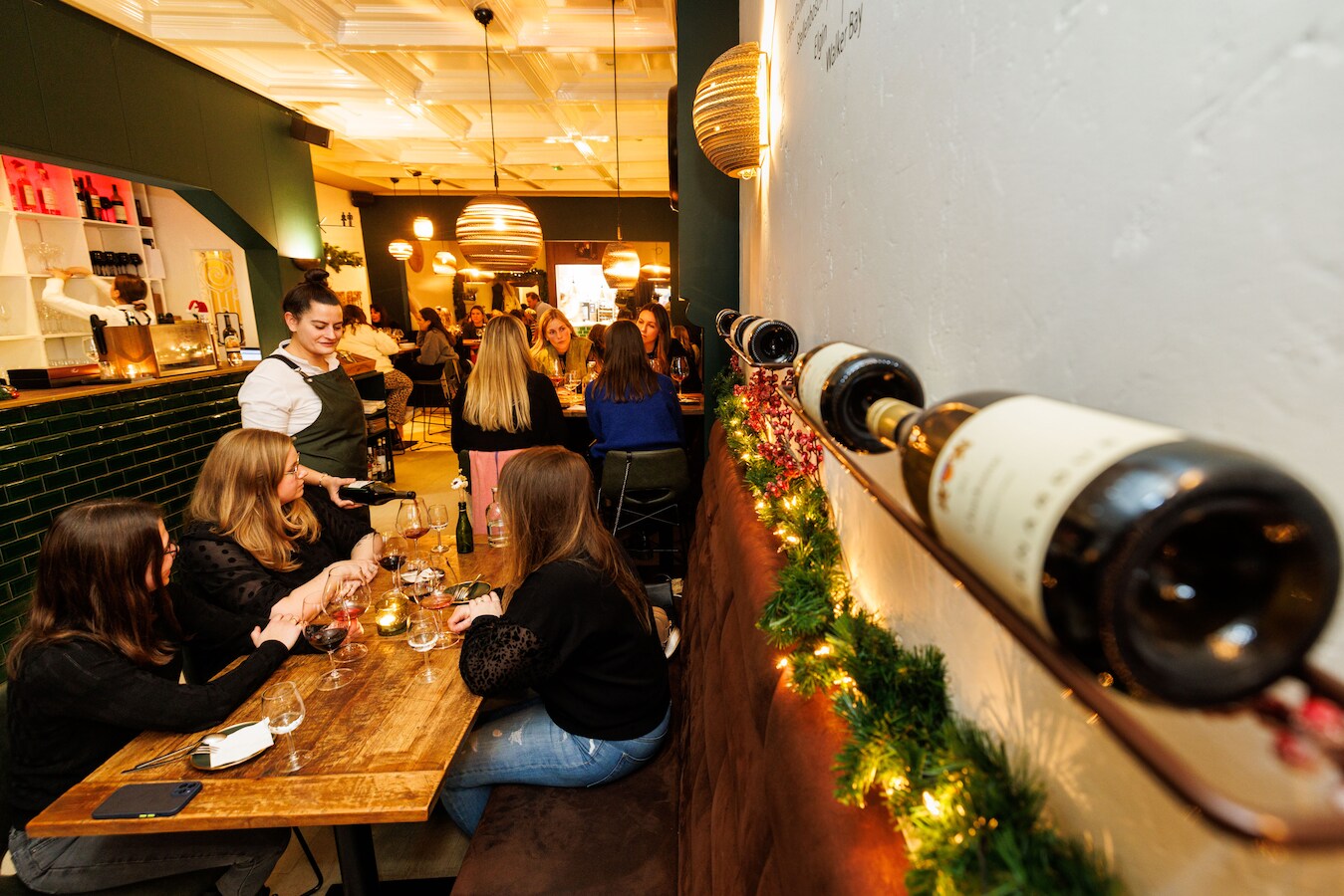 Sommelier Céline Court schenkt de wijn in voor een gezelschap bij Wijnbar Pinot 